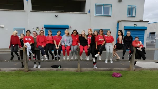 Un grupo de estudiantes se encuentra frente a un edificio con acentos azules en el terreno de St. Paul's Secondary School en Kildare.