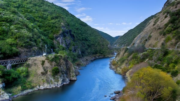 Un pintoresco valle montañoso con un río y un puente cerca de St. Peter's College.
