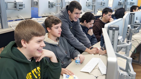 Estudiantes de la St. Peter’s High School trabajan juntos en computadoras en el aula de computación.