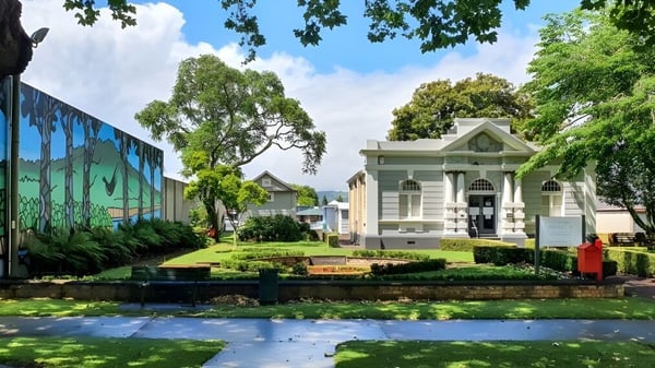 Un jardín verde con un pequeño lago en el terreno de la St. Peter's School Cambridge.