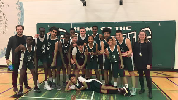 El equipo de baloncesto de la St. Pius X High School posando juntos en el gimnasio.