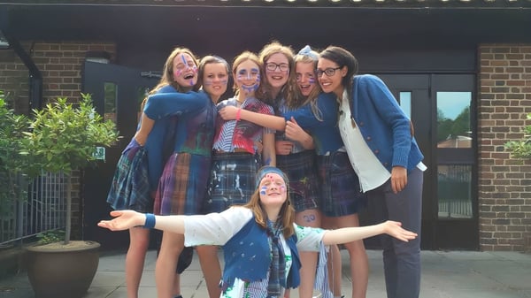 Un grupo de alumnas está frente a un edificio de ladrillo en el campus de St. Swithun's School.