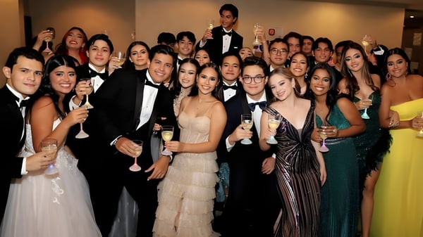 Un gran grupo de personas vestidas formalmente posan para una foto en la St. Tiernan’s Community School.
