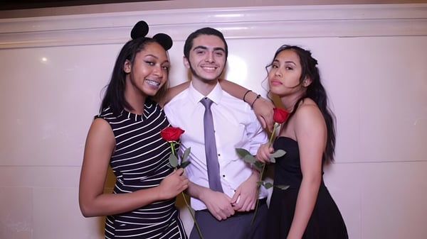 Tres personas posan juntas en el campus del Stephen Leacock Collegiate Institute en un área interior.