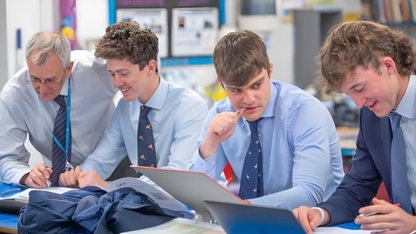 Un grupo de estudiantes de la Stephen Perse Foundation trabaja en conjunto en una laptop en un aula.