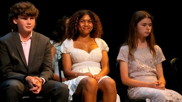 Tres personas sentadas con ropa formal en un escenario durante un evento de la Stevenson School.
