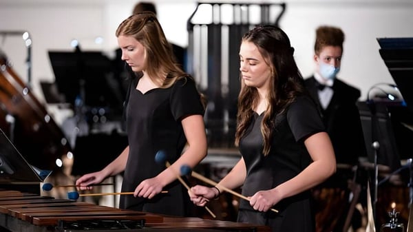 Dos estudiantes de la Stillwater Christian School tocan instrumentos de percusión en el escenario.