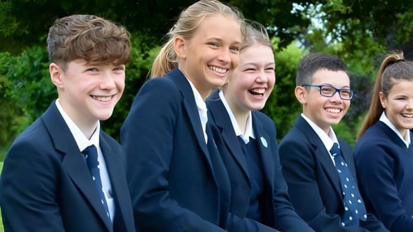 Un grupo de estudiantes de la Stonar School está sonriendo juntos en el área verde exterior.