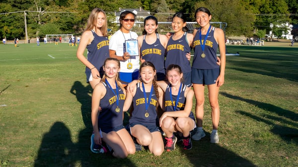 Un grupo de jóvenes atletas posan juntas en una pradera en el terreno de la Storm King School.