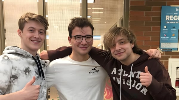 Tres estudiantes de la Stouffville District Secondary School posan frente al lugar de registro en la escuela.