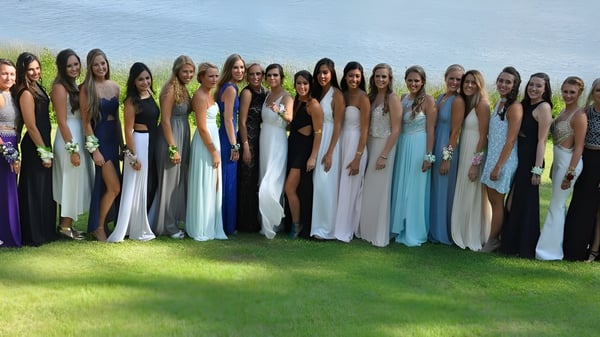 Un grupo de estudiantes de la Stouffville District Secondary School está de pie en un campo bajo un cielo azul.