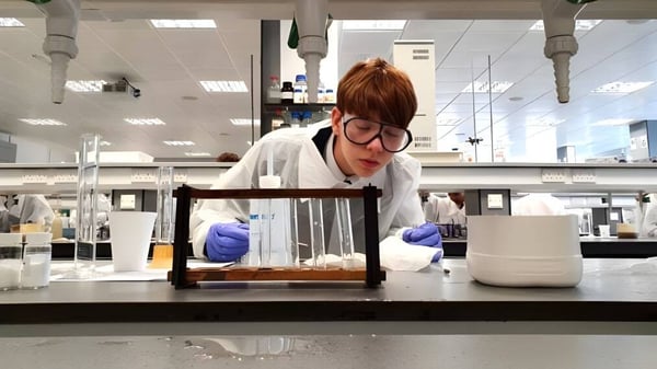 Una persona con bata blanca realiza un experimento en un laboratorio de la Strathallan School.