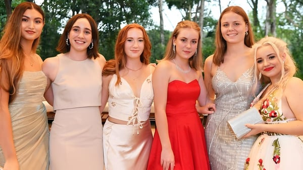 Seis estudiantes con cabello rojo están juntas en un área verde en el terreno de la Sunshine Beach State High School.