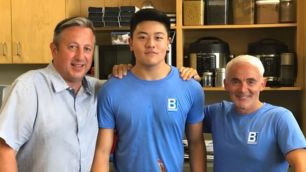 Tres personas están juntas en una cocina o despensa de la Sutherland Secondary School.