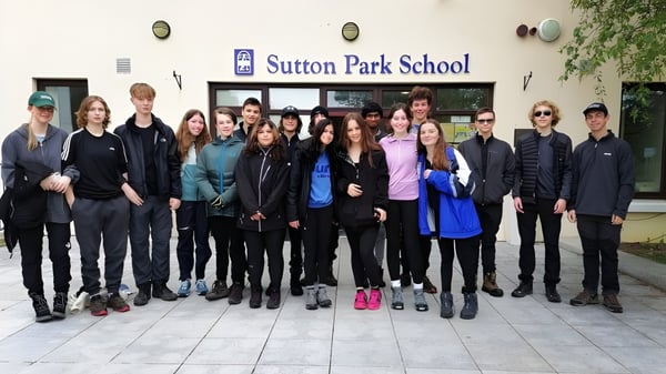 Un grupo de estudiantes se encuentra frente al edificio de la Sutton Park School en Dublín.