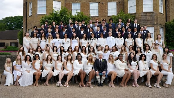 Un grupo de estudiantes frente a un edificio histórico en el campus de TASIS The American International School in England.
