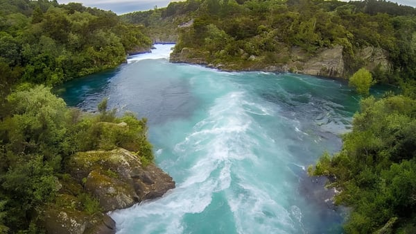 Un río color turquesa fluye a través de un cañón rocoso en medio de un paisaje boscoso cerca del Tauhara College.