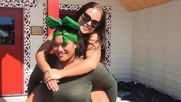 Dos personas se abrazan en un interior en el campus de la Te Puke High School.