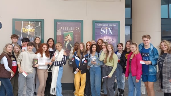 Estudiantes de The Hammond School están frente a un teatro con carteles de las obras Othello y Sex.