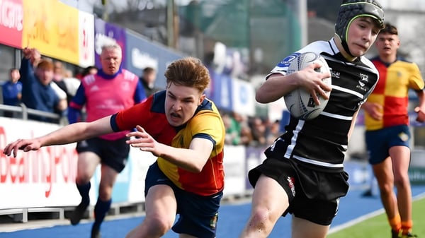 Dos deportistas compiten en uniformes deportivos en una competencia en el campo de deportes de The High School.