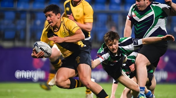 Estudiantes de The Kings Hospital juegan al rugby y luchan en un tackle en el campo.