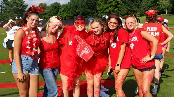 Un grupo de jóvenes mujeres posan en un prado en el campus de The Madeira School.