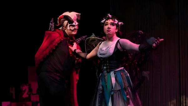 Dos personas en disfraces llamativos están en el escenario del teatro de The Pennington School.