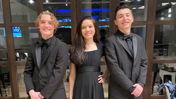 Tres personas en ropa formal en un evento en el campus de The Vanguard School.
