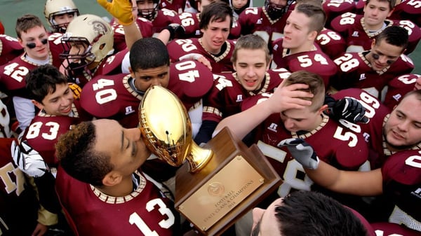 Un grupo de futbolistas celebra la obtención de un trofeo en el terreno de Thornton Academy.
