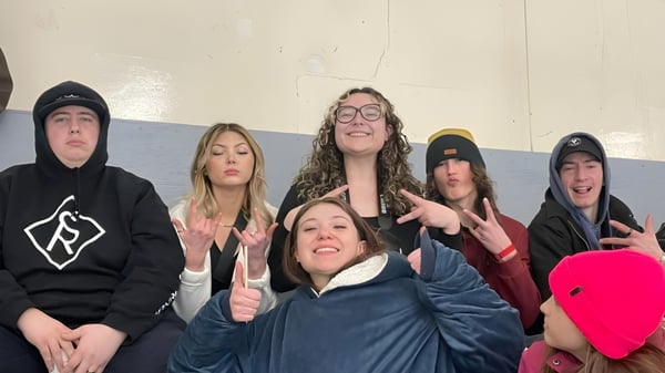 Un grupo de estudiantes de la Thorsby Junior Senior High School posan en un interior frente a una pared blanca.