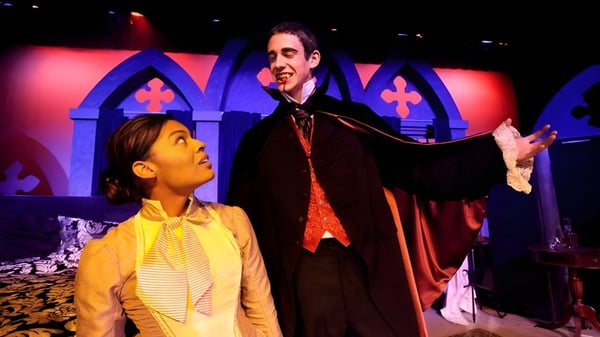 Dos personas están en el escenario de la Tower Hill School frente a un decorado gótico.