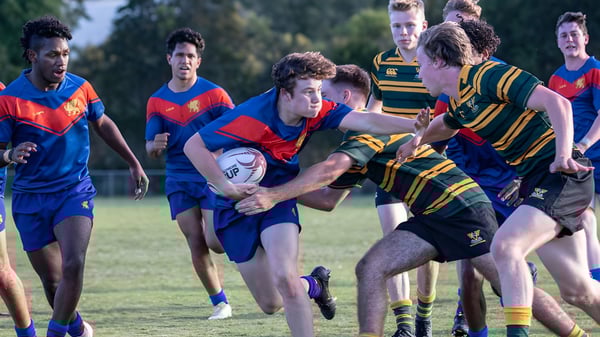 Estudiantes de la Townsville Grammar School juegan un intenso partido de rugby en el campo de césped.