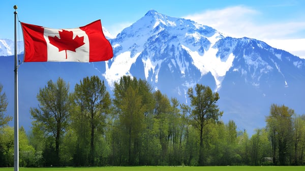 La bandera canadiense ondea frente a una montaña nevada en el terreno de la Trinity College School.