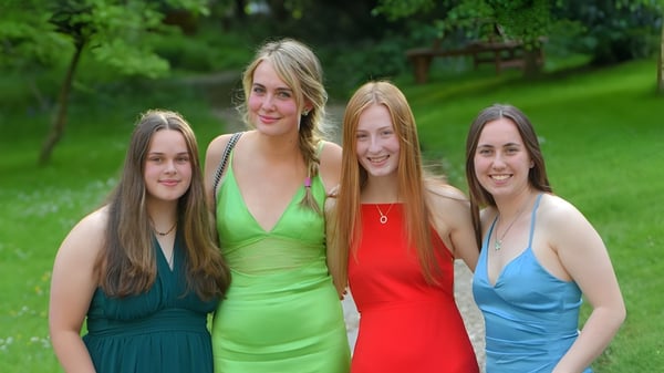 Cuatro alumnas de Truro School están juntas en un área verde exterior.