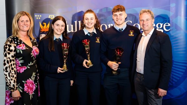 Un grupo de estudiantes del Tullamore College está frente a un fondo de Hogwarts en un evento de Harry Potter.