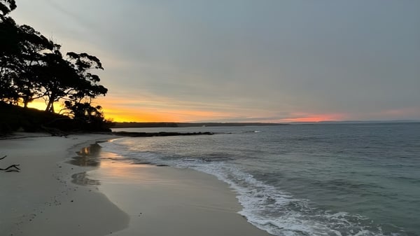 Una playa tranquila con suaves olas y un atardecer en el UC Lake Ginninderra.