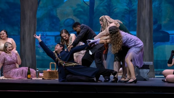 Estudiantes de la University of North Florida presentan una obra de teatro en un escenario con un fondo de bosque místico.