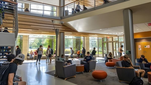 Personas en la amplia lobby con acentos de madera y paredes de vidrio en la University of Wisconsin-Superior.