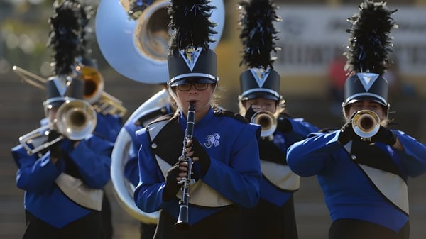 La banda de música del Upper Canada College se presenta en un escenario frente a un estadio.