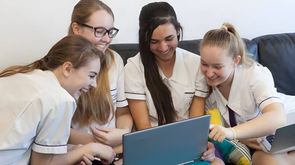 Un grupo de estudiantes del Upper Coomera State College trabaja en conjunto en un portátil.