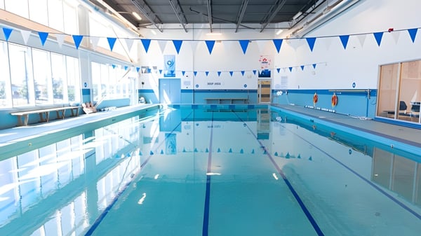 La piscina cubierta de la Urban International High School muestra una decoración en azul y blanco y banderas decorativas en el techo.