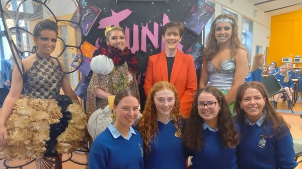 Un grupo de estudiantes de la Ursuline Secondary School Thurles posan frente a un logo de la ONU en la escuela.