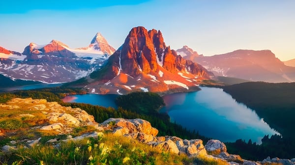 Paisaje montañoso con picos cubiertos de nieve y lago cerca de la Vernon Secondary School.