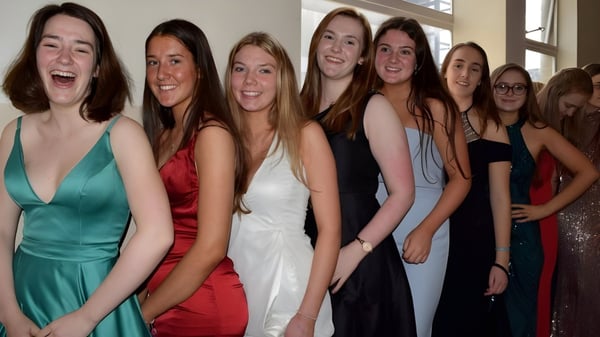 Un grupo de jóvenes mujeres vestidas de forma formal posan juntas en una fiesta en el Victoria College Belfast.
