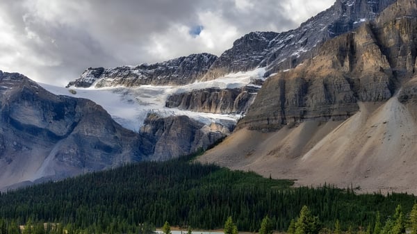 Montañas cubiertas de nieve y laderas boscosas se pueden ver en el paisaje frente a la Viking School.