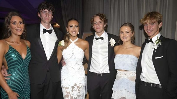 Un grupo de personas bien vestidas posan juntas en un evento formal de la Villiers School.