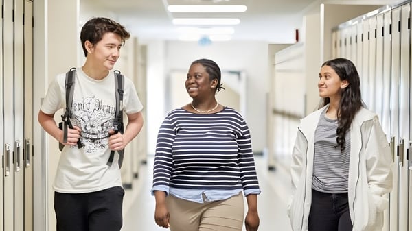 Tres estudiantes caminan juntos por el pasillo del Institut Collégial Vincent Massey Collegiate.