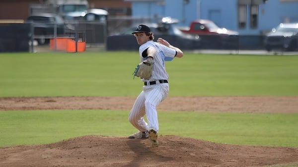 Un jugador de béisbol se prepara en el montículo del lanzador en el estadio del Virginia Beach City Public School District para un lanzamiento.