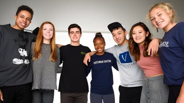 Un grupo de estudiantes de la Vistamar School posan sonriendo juntos en un ambiente relajado.