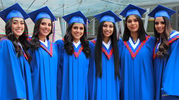 Un grupo de estudiantes de la W.P. Wagner High School celebra su graduación en togas y birretes azules.